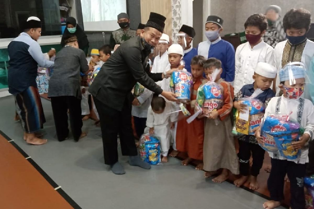 Para donatur memberikan santunan dan bingkisan kepada anak yatim.