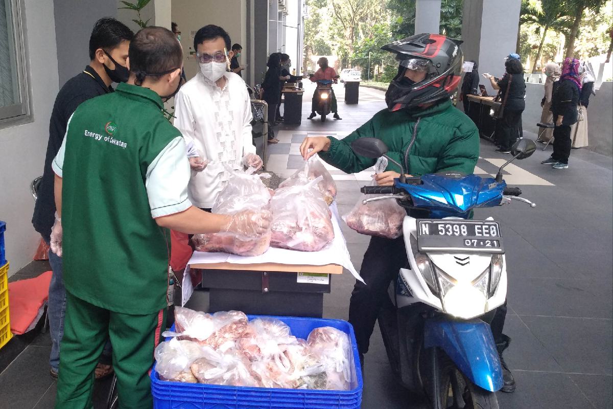 Pengambilan daging hewan kurban dari atas motor.