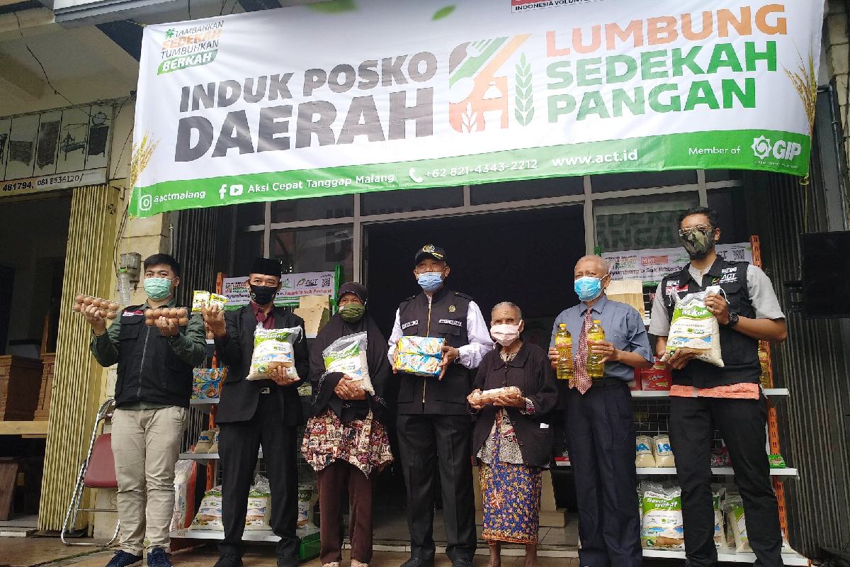 Penyerahan sedekah pangan bagi masyarakat yang membutuhkan.