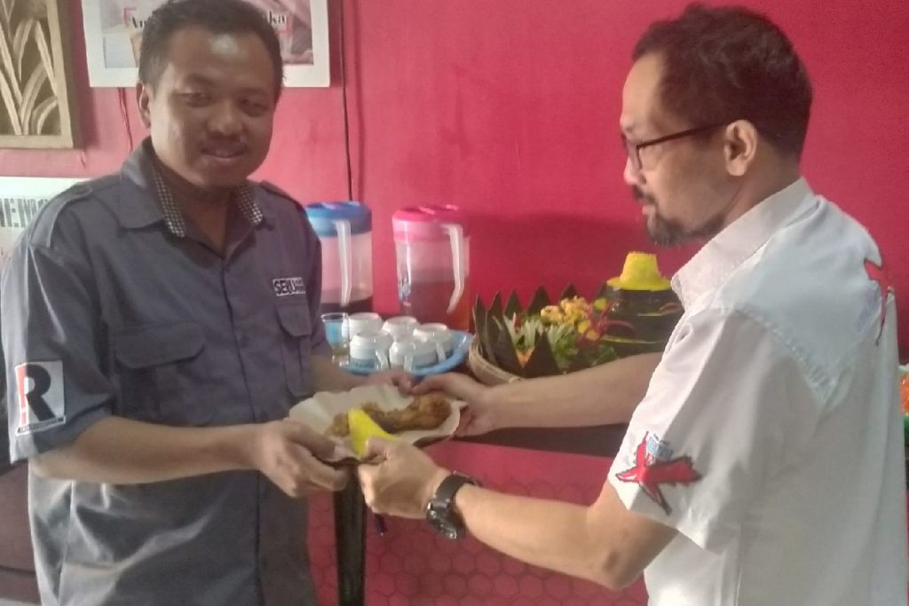 Pimred media kakak tertua Memo X, Endik Junaedi, memberikan potongan tumpeng kepada Pimred adik media SERU.co.id, Rahadi Adnil.