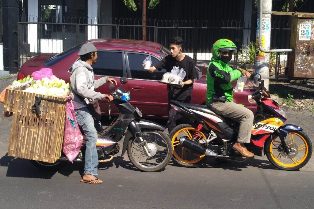 Pegiat Kopi Malangan bagikan cup kopi ke pengendara yang melintas. (rhd)