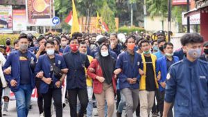 Demo mahasiswa dan buruh - Jakarta, SERU.co.id – Penolakan terhadap Undang-Undang Cipta Kerja atau Omnibus Law masih terus terjadi. Hari ini, Selasa (20/10/2020), massa gabungan dari mahasiswa dan buruh kembali menggelar aksi unjuk rasa. Aksi kali ini diselenggarakan di Kawasan Patung Kuda Arjuna Wijaya, Jakarta Pusat. Unjuk rasa kali ini menyuarakan agar presiden Joko Widodo mencabut UU Ciptaker dengan mengeluarkan Peraturan Pemerintah Pengganti Undang-Undang (Perppu). Menurut Koordinator Pusat Aliansi BEM Seluruh Indonesia (BEM SI), Remi Hastian, massa yang ikut aksi kali ini berjumlah 5.000 orang. “Aksi akan dilaksanakan pada Selasa, 20 Oktober 2020 pukul 13.00 WIB, dengan estimasi massa aksi sebanyak 5.000 mahasiswa dari seluruh Indonesia,” kata Remi. Remi mengatakan, keputusan pemerintah untuk meneruskan pembahasan UU Ciptaker seolah menantang rakyat. Padahal, menurutnya, pemerintah bisa mencabut UU tersebut. “Kami sangat menyayangkan keputusan pemerintah yang justru menantang masyarakat untuk melakukan judicial review terhadap UU Cipta Kerja padahal mereka bisa melakukan tindakan untuk mencabut undang-undang tersebut," ujar Remi. Koordinator Wilayah BEM se-Jabodetabek-Banten Aliansi BEM SI, Bagas Maropindra menyuarakan, permintaan massa mahasiswa untuk bertemu langsung dengan Presiden RI Joko Widodo. “Kita minta Pak Presiden keluar (menemui demonstrasi), karena massa aksi di sini jumlahnya banyak,” seru Bagas. Selain mahasiswa, massa buruh dari Gabungan Serikat Buruh Indonesia (GSBI) juga turut serta. Namun, massa buruh tak bergabung dengan mahasiswa. Dikutip dari Tempo, mereka memilih lokasi demo di depan kantor Indosat. Baik mahasiswa maupun buruh, sama-sama meneriakkan tuntutan mereka. Isi orasi keduanya senada, yaitu menolak UU Ciptaker. Untuk mengamankan aksi, Polres Metro Jaya menyiagakan puluhan ribu personel. Polri juga dibantu oleh personel TNI. “Personel yang sudah kita setting di lapangan untuk mengantisipasi baik itu di titik pusatnya di Patung Kuda dan Gedung DPR ini sudah kita setting semuanya itu ada 10.587 personel,” ujar Kabid Humas Polda Metro Jaya, Kombes Yusri Yunus. Selain Istana dan Gedung DPR, personel TNI/Polri juga disiagakan di sejumlah titik lain. Lokasi tersebut dinilai rawan saat terjadi demo. “Ada objek-objek lain selain Gedung DPR dan Istana Negara, ada beberapa-beberapa sentra-sentra perekonomian yang kita lakukan pengamanan, kita lapis di sana. Kemudian ada sentra-sentra perbelanjaan, mall yang kita nilai rawan kita siapkan pengamanan di situ,” imbuh Yusri. Gelombang penolakan UU Ciptaker telah berlangsung sejak awal Oktober ini. Unjuk rasa besar terjadi pada Kamis (8/10/2020). Mahasiswa dan buruh turun ke jalan di sejumlah wilayah di seluruh Indonesia untuk menolak UU Ciptaker. Pemerintah tak memenuhi permintaan massa dan melanjutkan pembahasan UU Ciptaker. Dewan Perwakilan Rakyat (DPR) juga telah menyerahkan draf UU ini ke Presiden Jokowi pada Rabu (14/10/2020) lalu. (hma/rhd) Tolak Omnibus Law, Tolak UU Ciptaker, Demo Tolak Ciptaker, BEM SI, Buruh Peristiwa Area lampiran