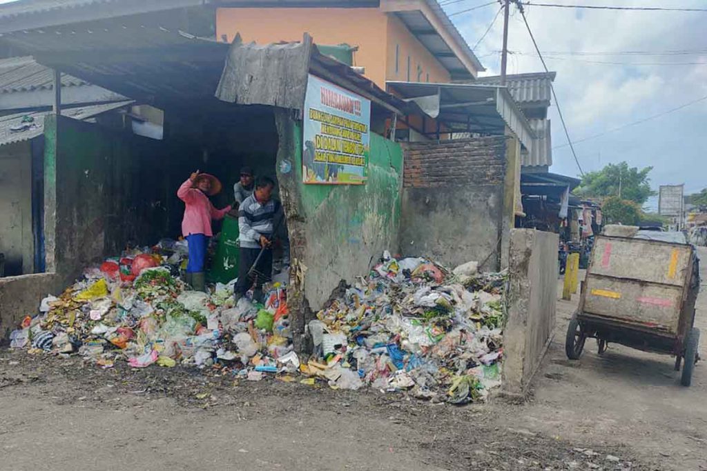 Petugas jaga piket TPS Pasar Genteng II membersihkan sampah