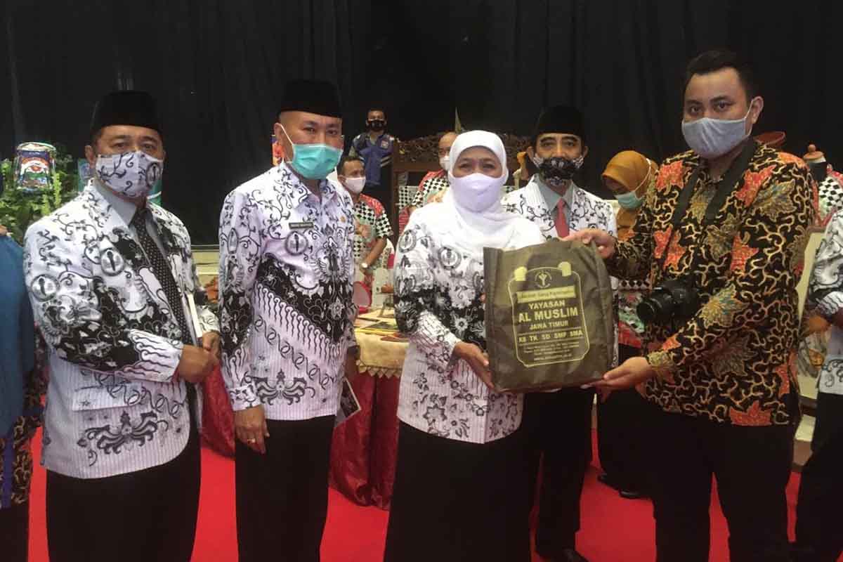 KUJUNGAN : Humas Al Muslim SMA Al Muslim, Azam Afian Dinata menyerahkan buah tangan untuk Gubernur Jatim, Khofifah Indar Parawansa usai mengunjungi stan pameran teknologi pembelajaran SMA Al Muslim di Islamic Center Surabaya, Senin (23/11/2020). (Foto : Memo X/Sudarmawan) - Khofifah Sanjung Inovasi Teknologi Pembelajaran SMA Al Muslim