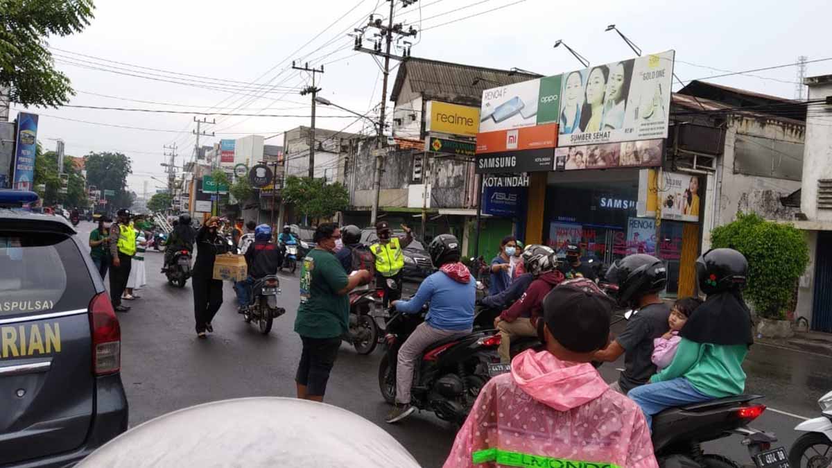 BAGIKAN - Para Bonek dan Bonita bersama Kapolsek Krian dan jajaran membagikan 1000 masker kepada pengguna jalan di depan Pasar Krian, Jumat (27/11/2020) - Bonek dan Kapolsek Krian Getol Bagikan 1.000 Masker