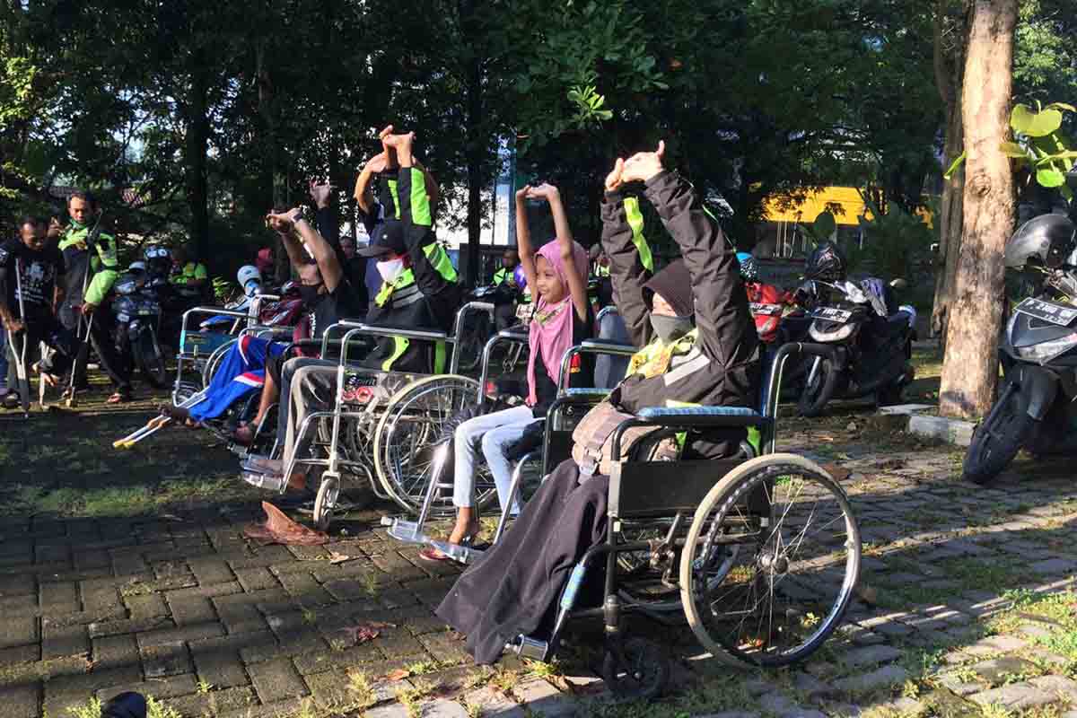 Para difabel dengan menggunakan kursi roda didorong oleh para pelari dan diikuti oleh anggota komunitas lainnya - Para Difabel Berkursi Roda Diajak Olahraga Lari