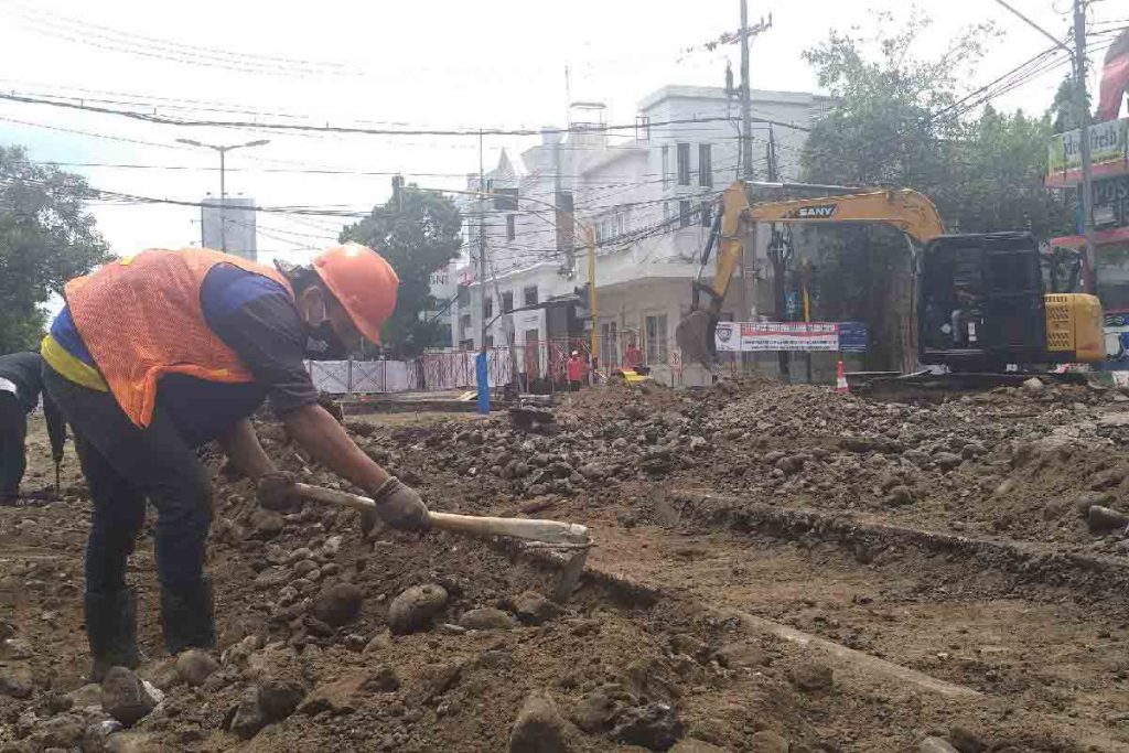 Pekerja berhati-hati mengangkat material di sekitar rel trem
