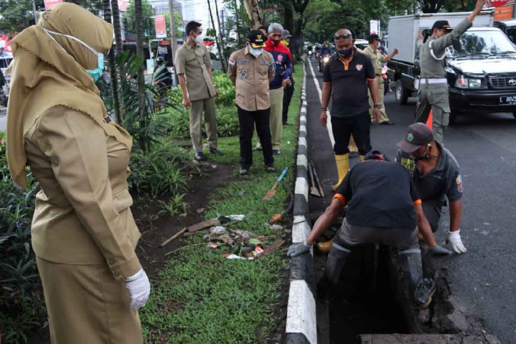 Petugas membersihkan sampah melalui bak kontrol. (ist) - Pasca Isolasi, Walikota Awali Dinas Sidak Kawasan Suhat
