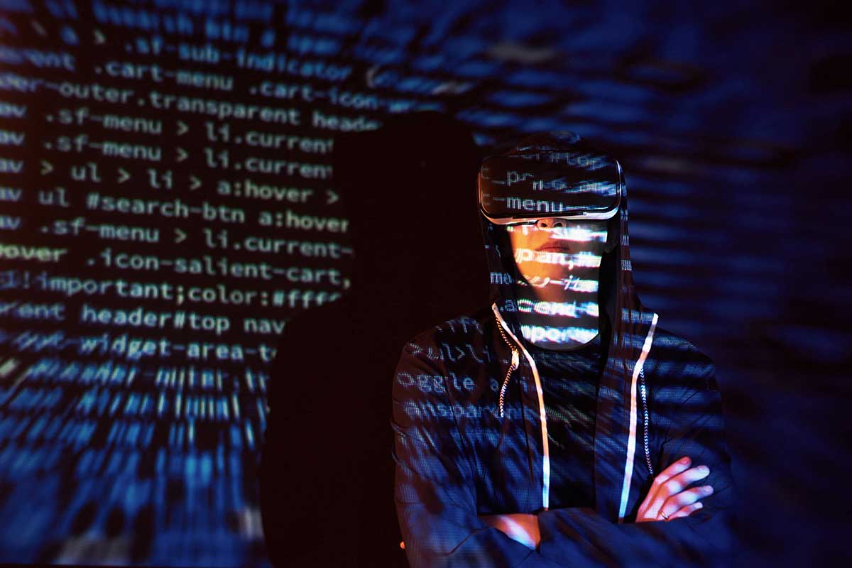 Cyber attack with unrecognizable hooded hacker using virtual reality, digital glitch effect