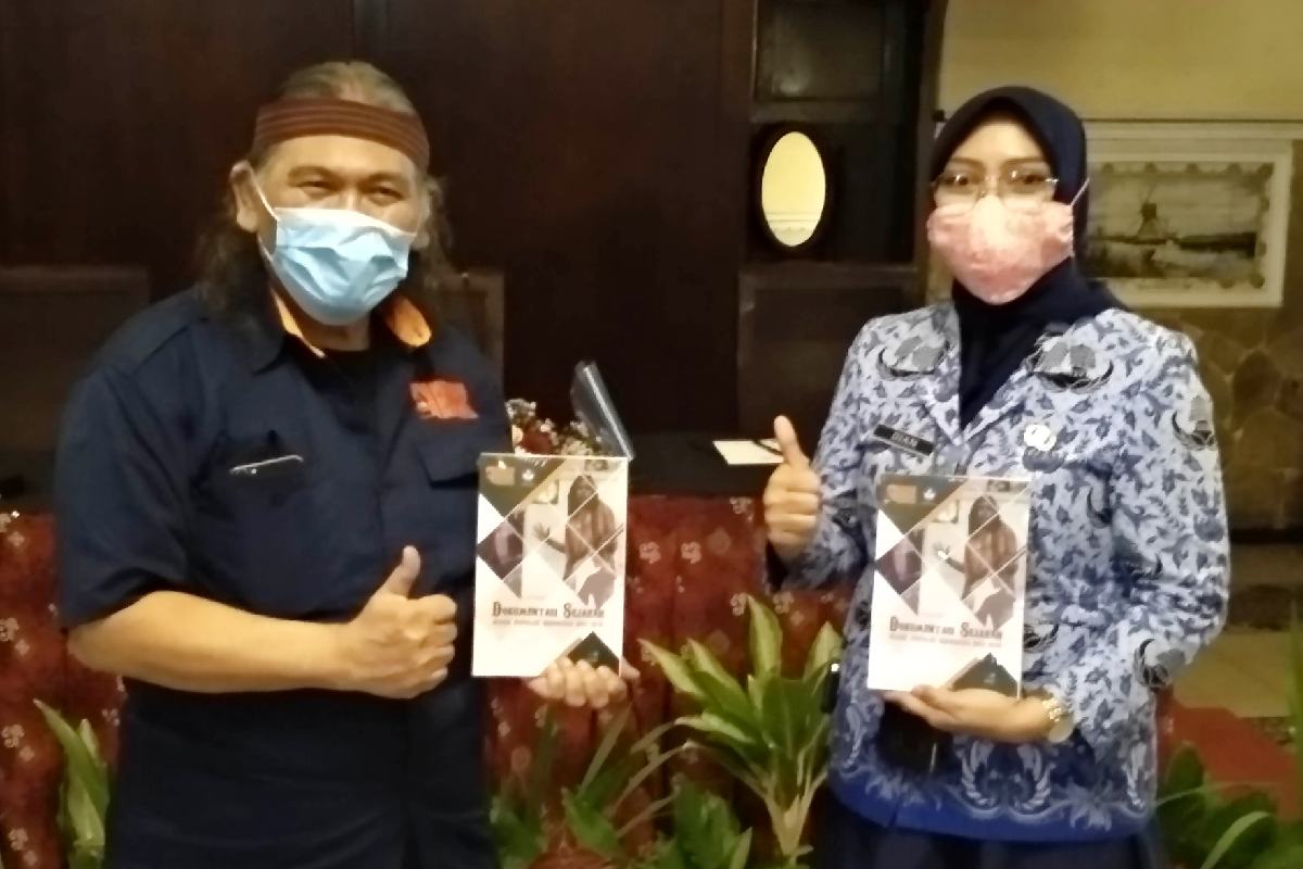 Hengki Herwanto dan Dian Kuntari menunjukkan buku katalog dokumentasi sejarah musik popular di Indonesia. (rhd) - Transformasi Digital ala MMI Abadikan Sejarah Musik di Indonesia