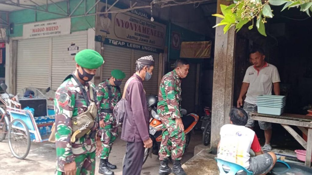 Koptu Hadi dan Kopda Jainal didampingi Koordinator PD Genteng 2, Taladin ketika melakukan sosialisasi penggunaan masker di Pasar Daerah (PD) Genteng II, Selasa (15/12/2020) siang. (ant) - Putus Mata Rantai Covid-19, 60 Personil Batalyon Yonif 527 Lumajang Ditugaskan Di Banyuwangi