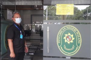 Djuanto menunjukkan pengumuman penutupan layanan kantor. (rhd) - Pengadilan Negeri Malang Tutup, Buntut 20 Karyawan Terpapar Covid-19