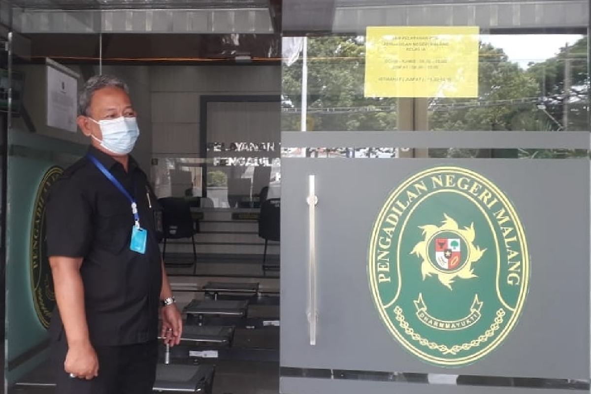 Djuanto menunjukkan pengumuman penutupan layanan kantor. (rhd) - Pengadilan Negeri Malang Tutup, Buntut 20 Karyawan Terpapar Covid-19