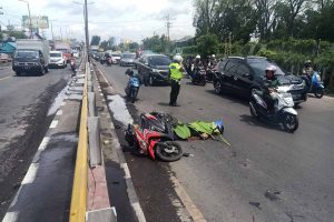 EVAKUASI - Petugas Unit Laka, Satuan Lantas, Polresta Sidoarjo mengevakuasi jenazah korban kecelakaan Hendri Susanto (41) pengendara motor Honda bernopol L 6456 ZR di JL Raya Waru, Kecamatan Waru, Sidoarjo, Senin (07/12/2020) - Bersenggolan, Pengendara Motor Tewas Terlindas Truk di Samping Fly Over Waru