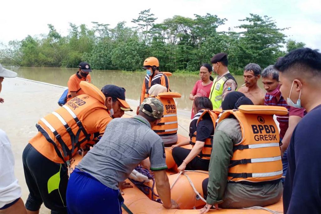 BANTUAN PERSONEL : Sejumlah bala bantuan dari BPBD Gresik diterjunkan di lapangan untuk mengevakuasi warga - Banjir Kali Lamong di Gresik Kembali Merendam Ratusan Rumah dan Hektaran Sawah