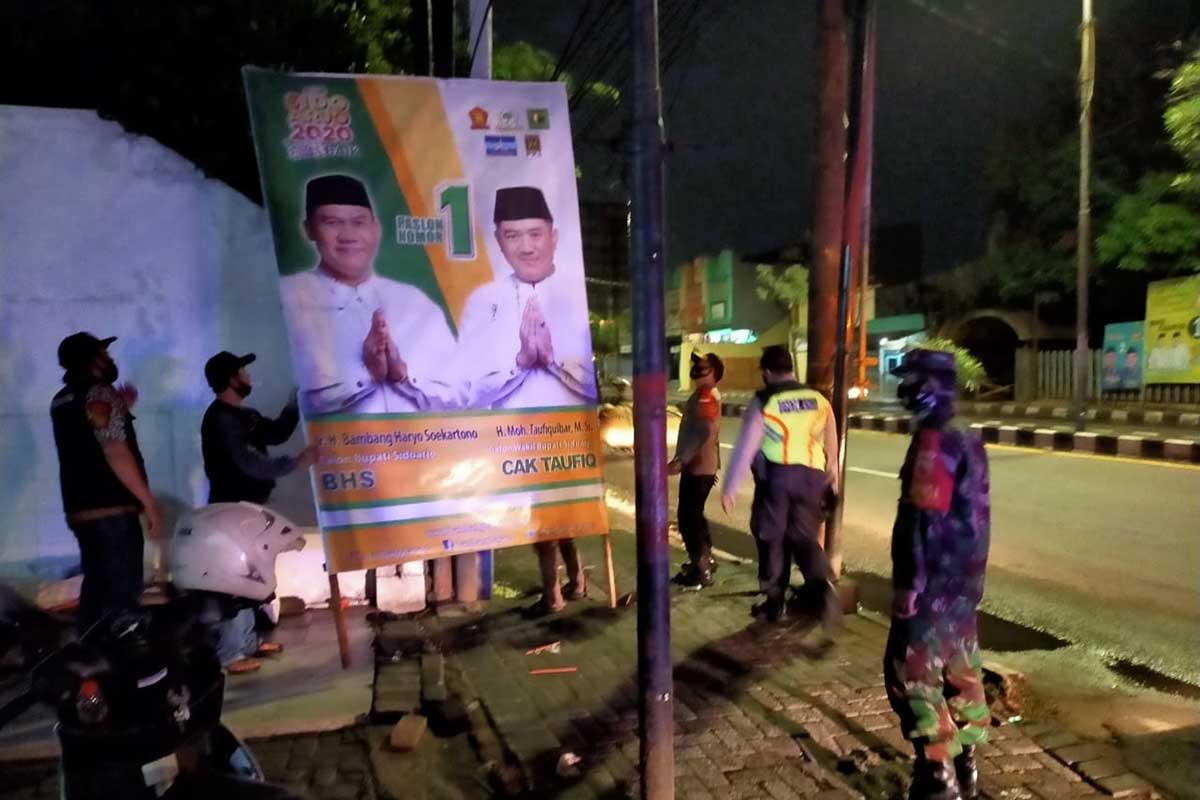TERTIBKAN - Sejumlah petugas gabungan menertibkan Alat Peraga Kampanye (APK) Cabup dan Cawabup Sidoarjo karena memasuki masa tenang, Minggu (06/12/2020) dini hari - Personel Gabungan Tertibkan APK Cabup dan Cawabup