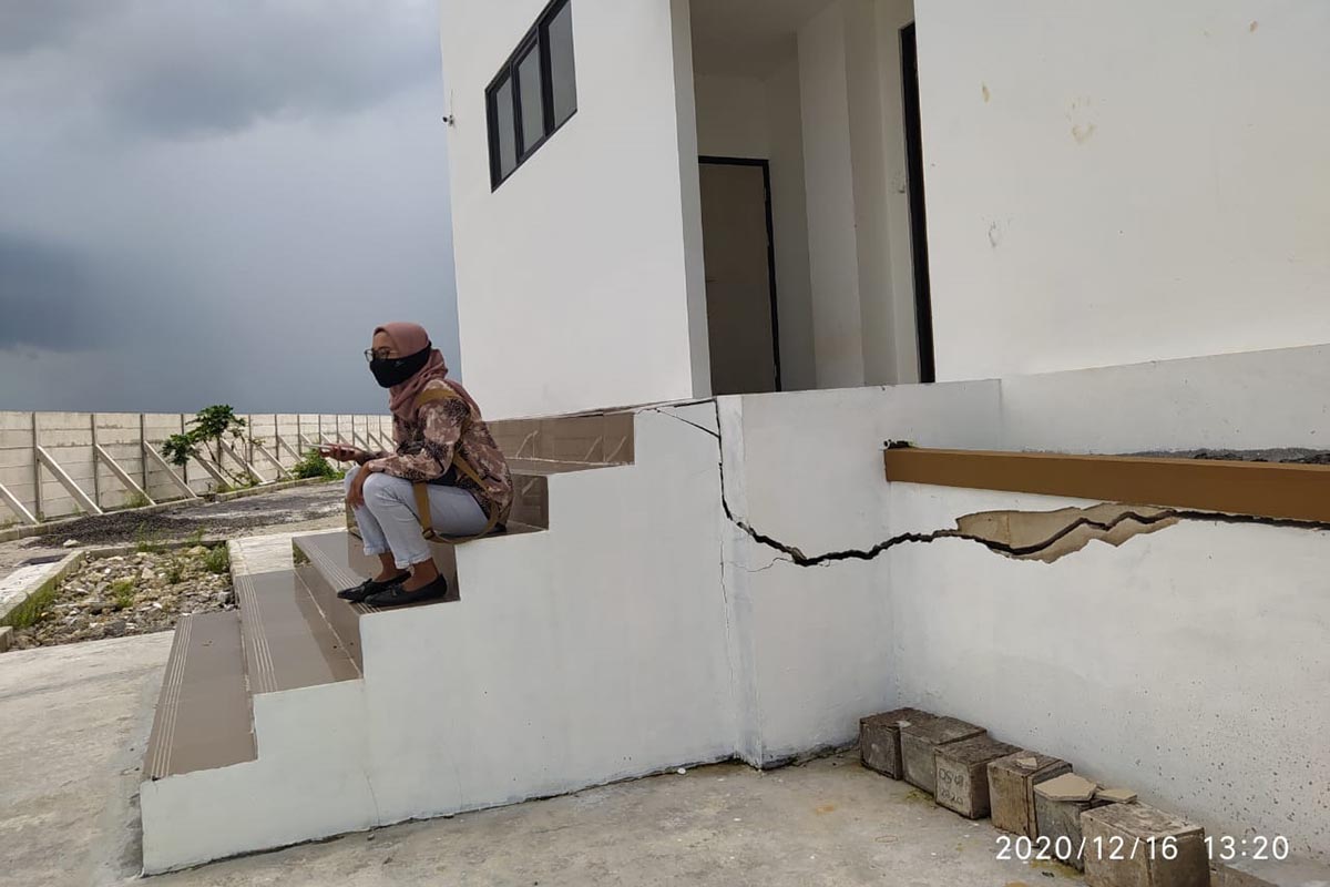 Seorang warga duduk diatas tangga di gedung DPRD yang retak - Belum Digunakan, Tangga Gedung DPRD Retak