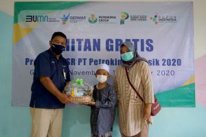 SERAHKAN BINGKISAN: VP CSR Petrokimia Gresik, Luqman Harun (kiri) menyerahkan bingkisan secara simbolis kepada peserta khitan gratis program CSR Petrokimia Gresik 2020 - Petrokimia Gresik Peduli, Khitan Gratis 23 Anak