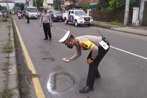 Anggota Satlantas Polres Mojokerto menandai jalan berlubang pakai cat - Tekan Angka Laka, Satlantas Inventarisir Jalan Berlubang