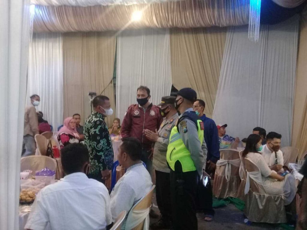 BUBARKAN - Sejumlah petugas gabungan dari Kecamatn Krian menghentikan hajatan salah satu warga di Desa Jerukgamping, Kecamatan Krian, Sidoarjo, Sabtu (23/01/2021) malam - Petugas Gabungan Hentikan Hajatan Pernikahan Warga Jerukgamping