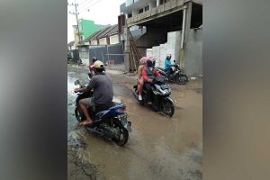 Jalan Raya Barengkrajan berkubang dipenuhi air mengganggu warga yang lewat. (par) - Akses Barengkrajan Berkubang di Tengah Jalan