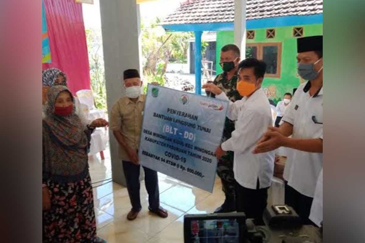 Kepala DPMD Kabupaten Pasuruan menyerahkan bantuan di salah satu desa - Dana Desa Kabupaten Pasuruan Naik Rp 600 Juta