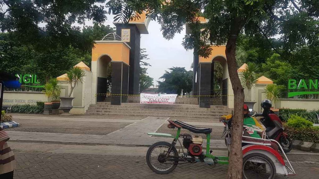 Petugas Satpol PP memasang police line di gapura alun-alun Bangil - Alun-Alun Bangil Disegel Satpol PP
