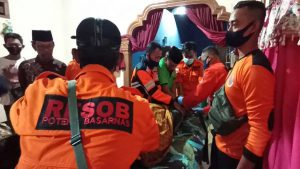 Petugas menyerahkan jasat korban kepada keluarga untuk dimakamkan - Pamit Cari Ikan, Ditemukan Tewas Tenggelam di Sungai Brantas