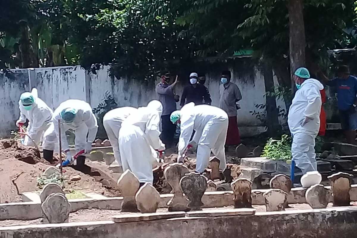 PEMAKAMAN : Petugas pemulasaran jenazah Covid-19 sedang mengubur jenazah. (Memo X/her) - Sehari 4 Pasien Covid-19 di Situbondo Meninggal