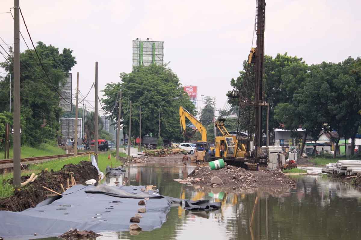 TERENDAM - Sejumlah alat berat yang digunakan mengerjakan proyek Frontage Road (FR) di bawah patung pesawat kawasan timur Aloha, Kecamatan Gedangan, Sidoarjo tergenang banjir hingga mesinnya sempat mogok, Selasa (19/01/2021) - Proyek Frontage Road Molor Terganjal Jaringan Pipa Gas