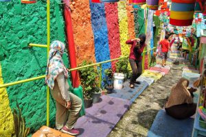 Pengunjung berfoto di tangga KWJ. (jaz) - Pengunjung Kampung Warna-warni Jodipan Menurun Drastis