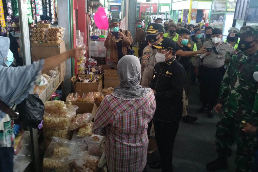 Pembagian masker di Pasar Bunulrejo. (rhd) - Sasar Keramaian, Operasi Penegakan Disiplin PPKM Bakal Tindak Pelanggar