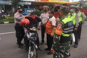 Berikan masker kepada pengendara motor. (ist) - Muspika Blimbing Patroli Gabungan PPKM Mikro Jilid I