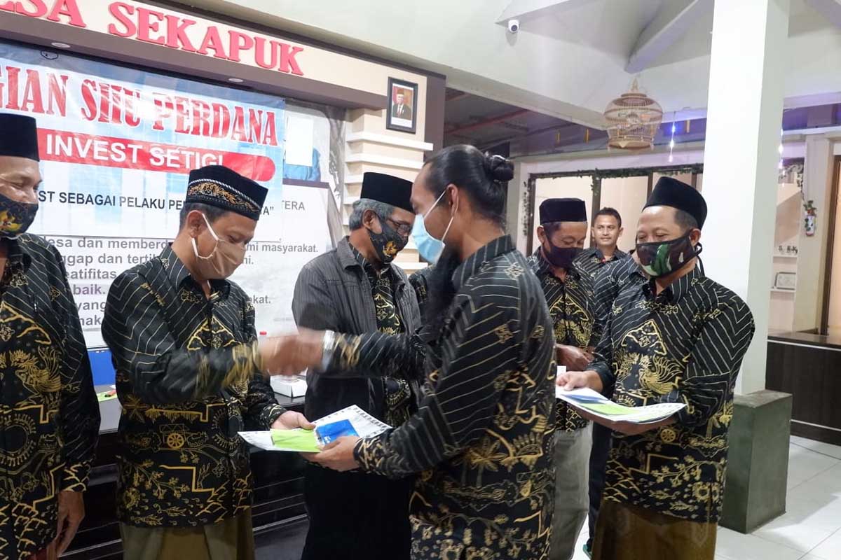 BAGIKAN SHU : Kades Sekapuk Abdul Halim saat membagikan SHU Setigi secara simbolis - Setigi Bagikan Ribuan SHU Warga Sekapuk Gresik