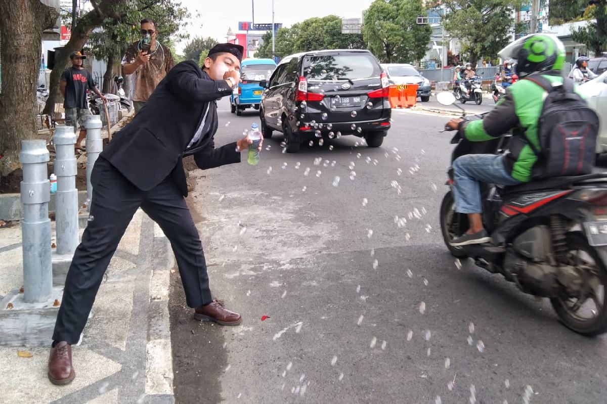 Salah seorang Mapert melakukan aksi teatrikal di Jalan Basuki Rahmat. (ws1) - Malang Performance Art Kritik Pemerintah Melalui Teatrikal Jalanan