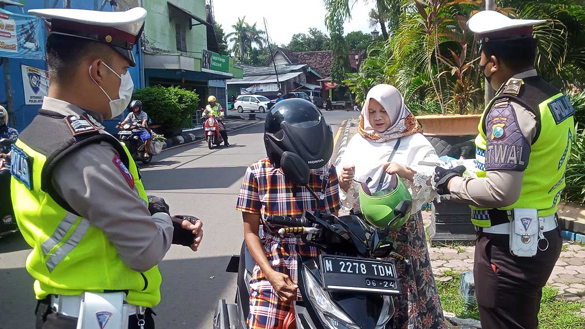 Petugas Satlantas Polres Pasuruan memberikan edukasi pada seorang pelanggar Lalin dan Prokes - Pengendara Abai Prokes Disetop Polantas
