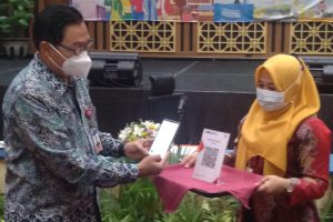 Kepala KPwBI Malang, Azka Subhan Aminurridho, menggunakan QRIS. (rhd) - Gapai 12 Juta Merchant QRIS, Bank Indonesia Gandeng ASPI dan PSJP
