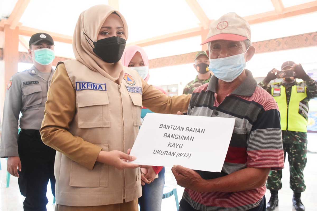 Bupati Ikfina menyerahkan bantuan kepada salah satu warga terdampak angina puing beliung - Dua Desa Terdampak Angin Puting Beliung Ditinjau Bupati