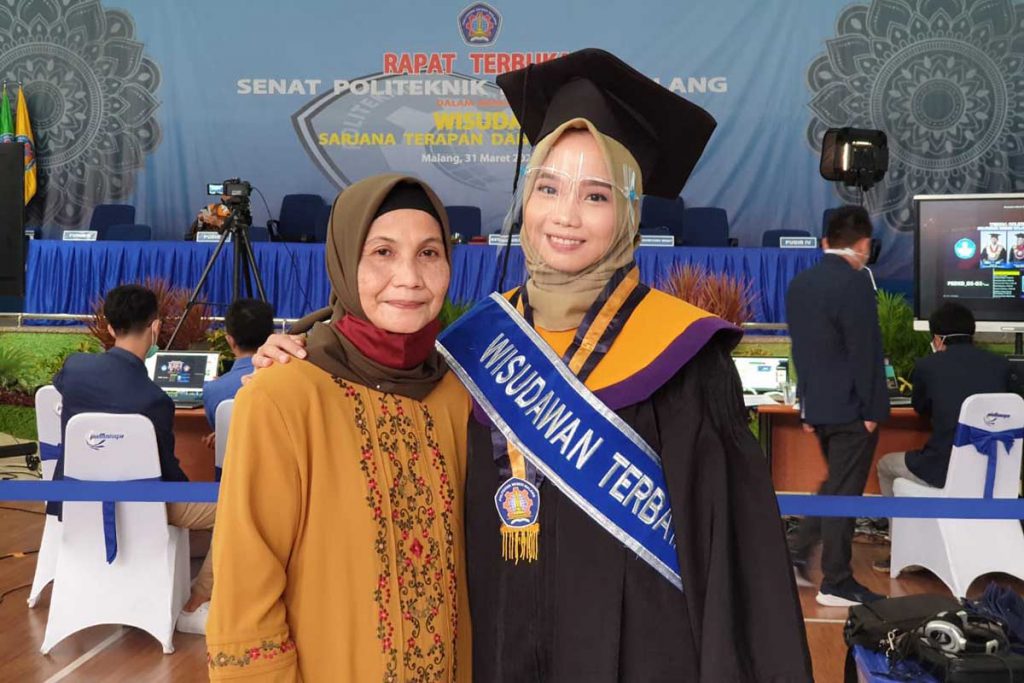Wisudawati terbaik Polinema, Aditya Vita Damayanti, bersama orang tua. (rhd) - Polinema Wisuda 558 Lulusan Secara Online