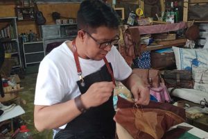 Endri Sulaksono, ketika menjahit tas berbahan dasar kulit. (ws2) - Terapkan Rastic Style, Pengrajin Kulit Kota Batu Jajaki Pasar Internasional