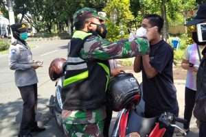 Petugas gabungan mengenakan masker kepada pelanggar. (ist) - Operasi Yustisi, Satgab Sukun Jaring 30 Pelanggar