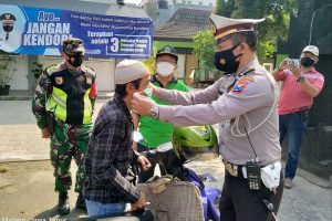 Petugas mengenakan masker kepada pengguna jalan kawasan Sumbersari. (ist) - Klaster Individu Meningkat, Aparat Gabungan Sasar Sumbersari Area Kampus