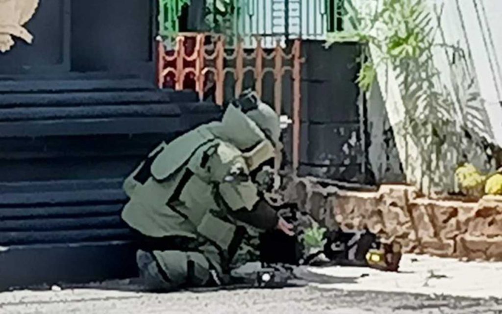Tim Gegana dengan mengenakan baju khusus seberat sekitar 40 kg mendekat ke lokasi tas untuk meletakkan alat deteksi bom - Tim Jihandak Gegana Polda Jatim Lakukan Evakuasi - Geger Penemuan Tas di Depan Kantor Dewan