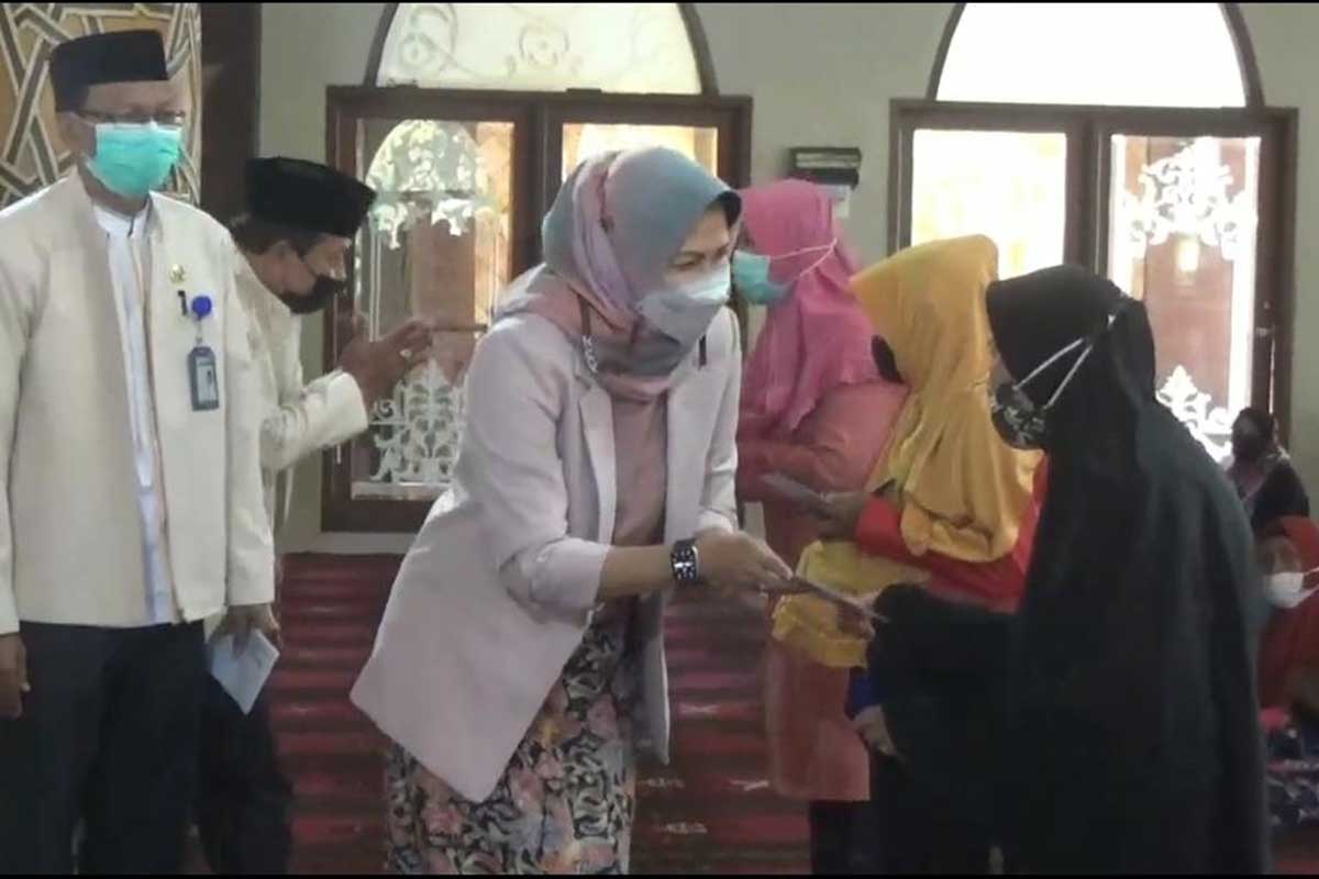Walikota Batu Dewanti Rumpoko ketika membagikan bantuan kepada masyarakat pra sejahtera. (ws2) - Penyaluran ZIS, Baznas Kota Batu Bagikan Pada 2.400 Warga