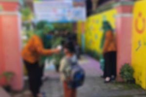 Guru TK sedang mengecek suhu siswa TK di gerbang masuk sekolah. (ilustrasi) - Diklarifikasi Status Guru TK, Jubir Lembaga TK: Tunggu Pimpinan Kami