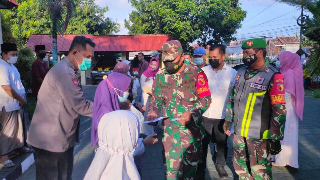 Kapolsek Banyuwangi Kota, AKP Kusmin dan Dandim 0825/01, Kapten Inf Sutaji saat membagikan santunan dan bantuan sembako kepada warga kurang mampu yang ada disekitar Mapolsek Banyuwangi Kota, Rabu (5/5/2021) sore - Polsek Banyuwangi Kota Bersama Koramil 0825/01 Banyuwangi Bagi Takjil Dan Santunan Anak Yatim
