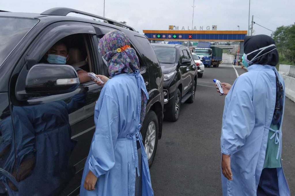 Petugas kesehatan memeriksa suhu tubuh pengendara. (ws1) - Tim Gabungan Amankan Penyekatan Exit Tol Madyopuro