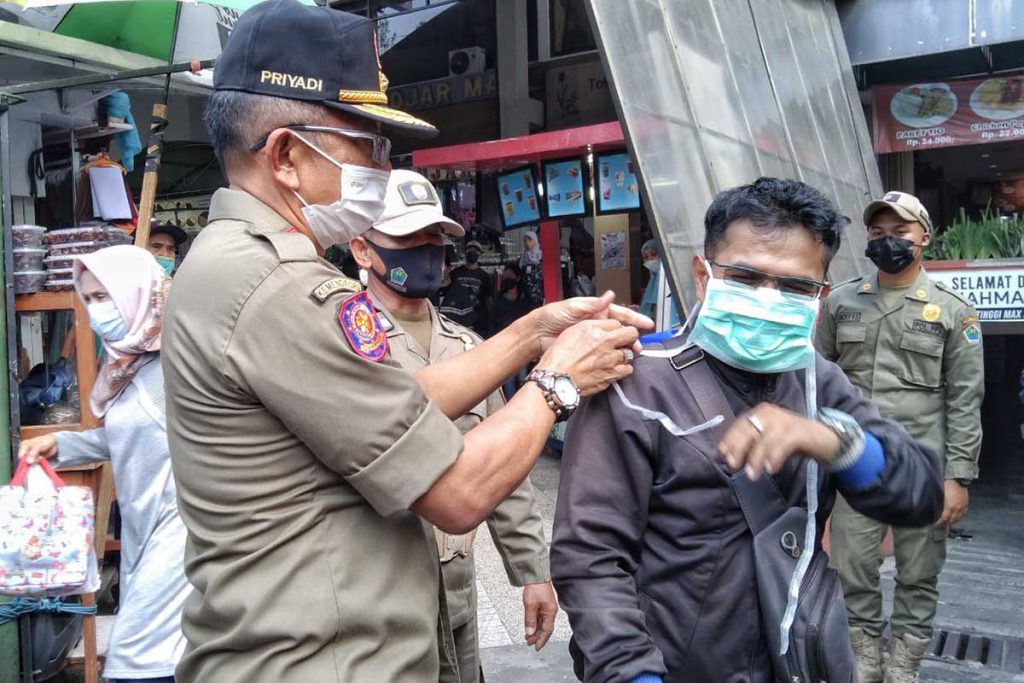 Petugas menegur dan memberikan masker bagi pelanggar. (ws1) - Jelang Hari Raya, Satpol PP Sidak Pusat Perbelanjaan