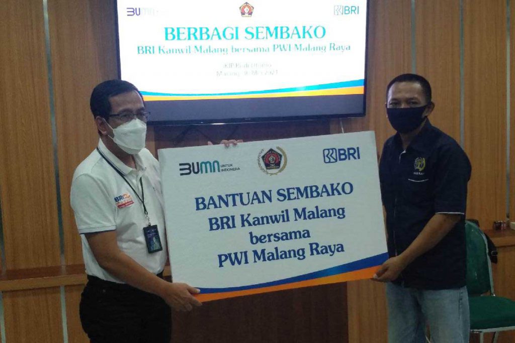 Simbolis kolaborasi BRI Kanwil Malang - PWI Malang Raya dalam penyaluran bantuan sembako. (rhd) - BRI Kanwil Malang - PWI Malang Raya Salurkan 250 Paket Sembako di 12 Titik Malang Raya