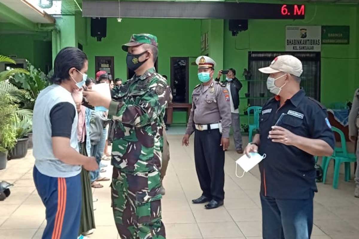 Pelanggar diberikan masker setelah menerima sanksi. (ist) - Operasi Yustisi Sawojajar Jaring 10 Pelanggar